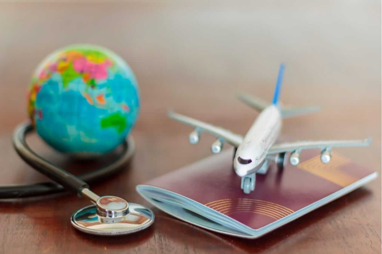 Composición visual con un globo terráqueo, un
estetoscopio, un avión de juguete y un pasaporte,
reflejando la seguridad en viajes.